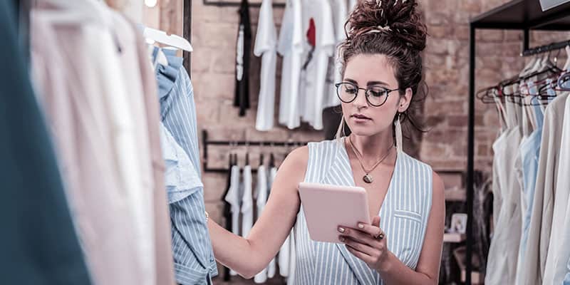A woman prices clothing in a retail store.